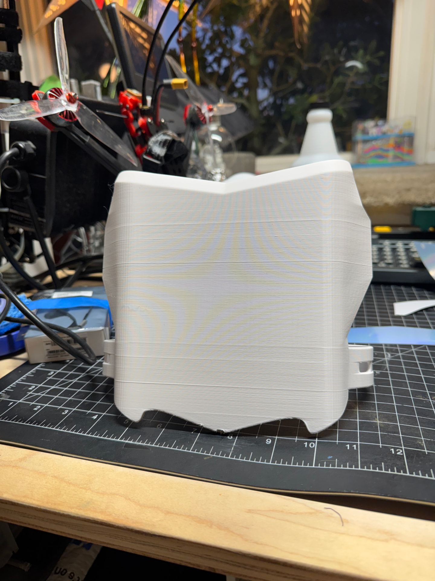 White 3D printed front plate on a cutting mat